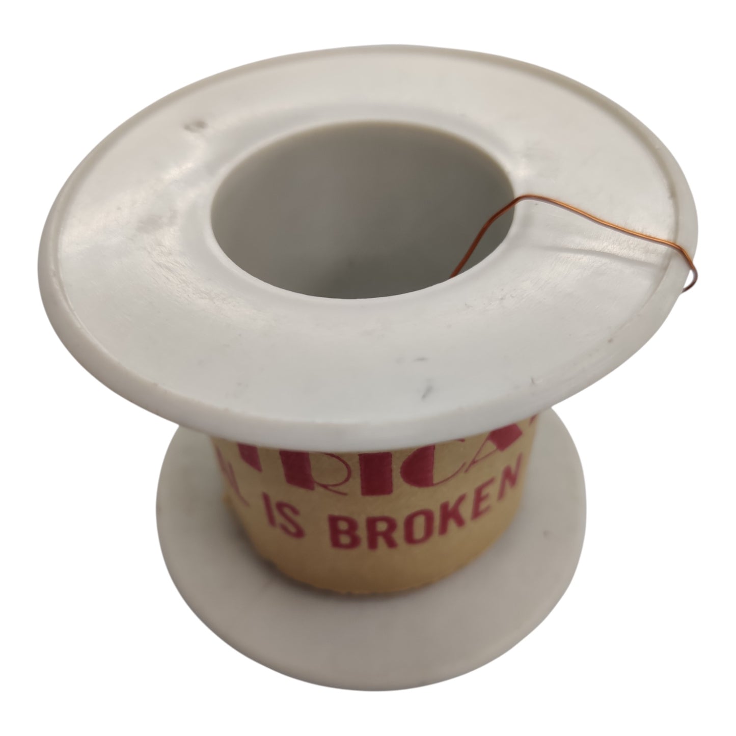 A white plastic spool with a cardboard core showing the text 'VIRTX IS BROKEN' in red, with a thin copper wire loop attached to the top.