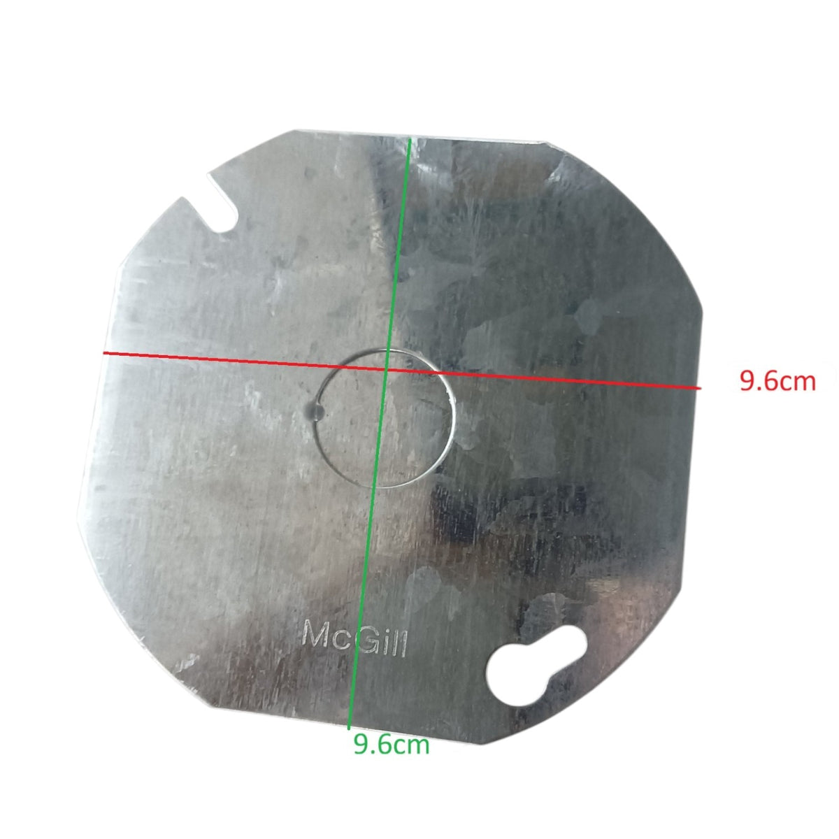 A square metal disc with rounded corners, a central circular hole, and two small cutouts, shown on a white background with red and green dimension lines indicating a 9.6 cm by 9.