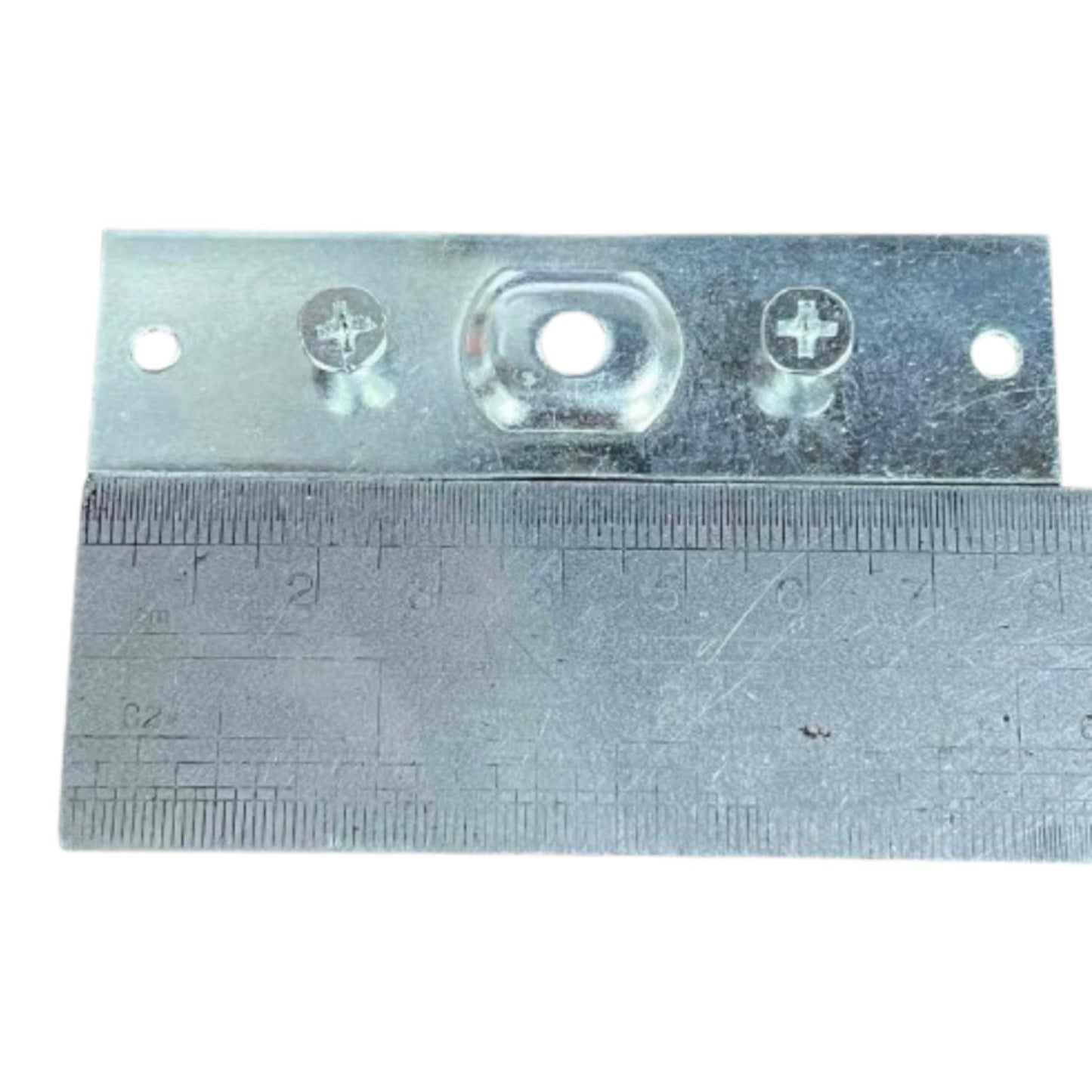 A galvanized metal mounting bracket with pre-drilled screw holes and a central oval cutout, shown with a metal ruler underneath for scale on a white background.
