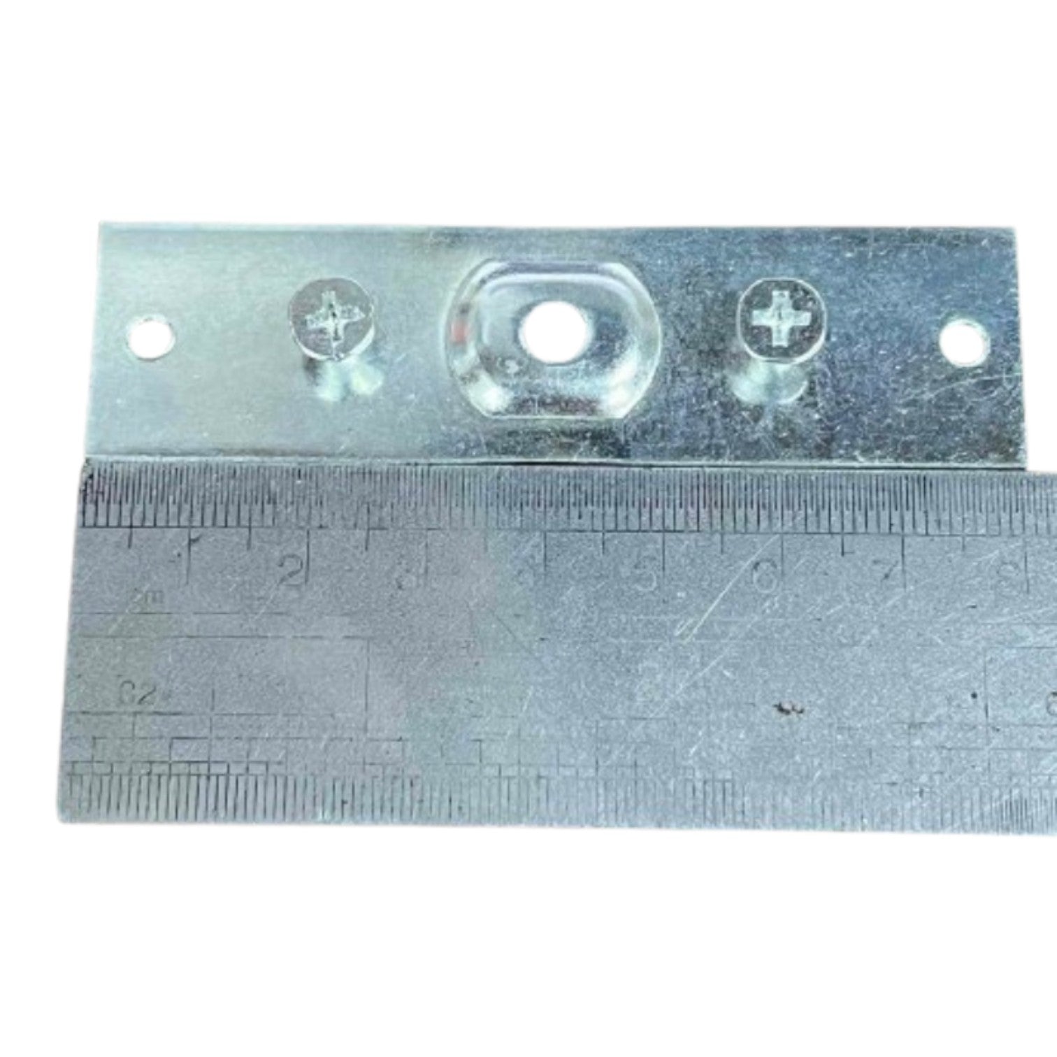 A galvanized metal mounting bracket with pre-drilled screw holes and a central oval cutout, shown with a metal ruler underneath for scale on a white background.