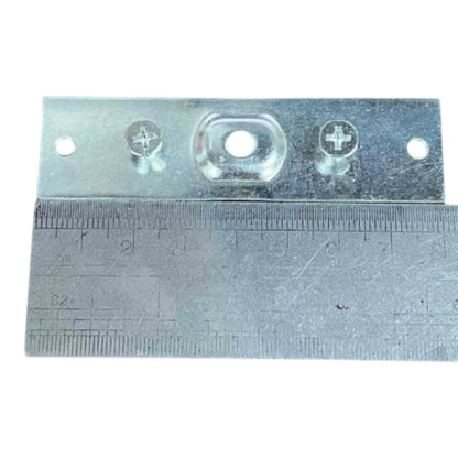 A galvanized metal mounting bracket with pre-drilled screw holes and a central oval cutout, shown with a metal ruler underneath for scale on a white background.