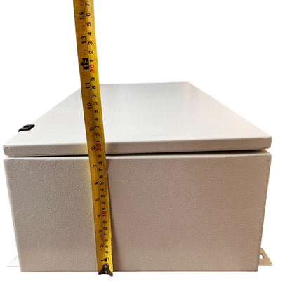 A light beige textured metal electrical junction box shown with a yellow tape measure standing vertically to indicate its height against a plain white background.