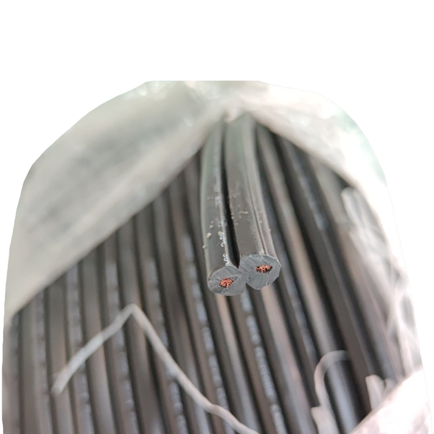A bulk bundle of black electrical cables or wires bundled inside a translucent plastic bag, with two cable ends exposed showing the cross-section and copper-colored inner conductors.
