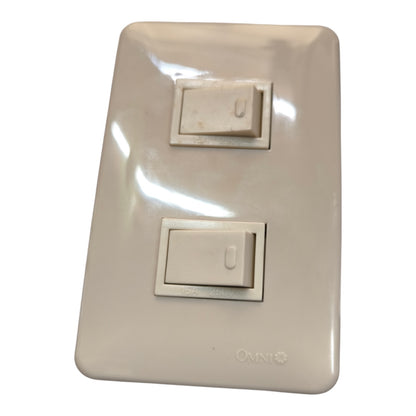 A double single-toggle wall switch plate in a warm off-white or cream color, featuring a glossy finish and the Omni brand name printed near the bottom right.
