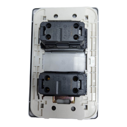 A close-up of a double-gang wall switch module showing the rear side with two black electrical sockets and a white plastic backplate.