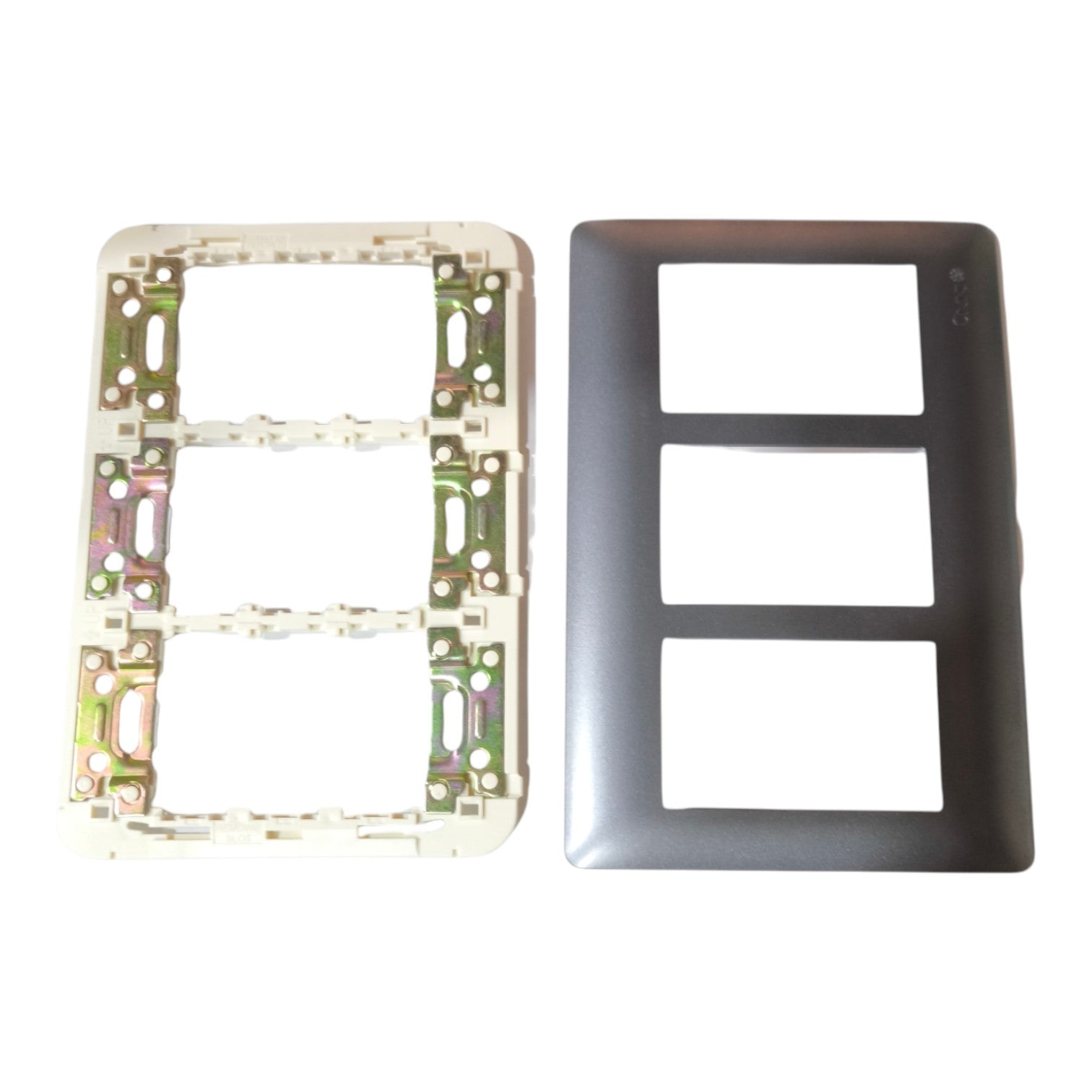 A two-piece electrical outlet cover plate set on a white background, featuring a dark gray three-toggle faceplate and its corresponding white backplate with internal metal mounting hardware.