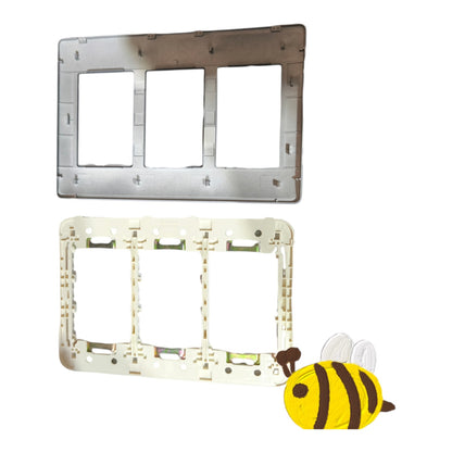 Two rectangular wall plate frames shown on a white background, one metallic silver and one off-white, with a small cartoon bee graphic in the lower right corner.
