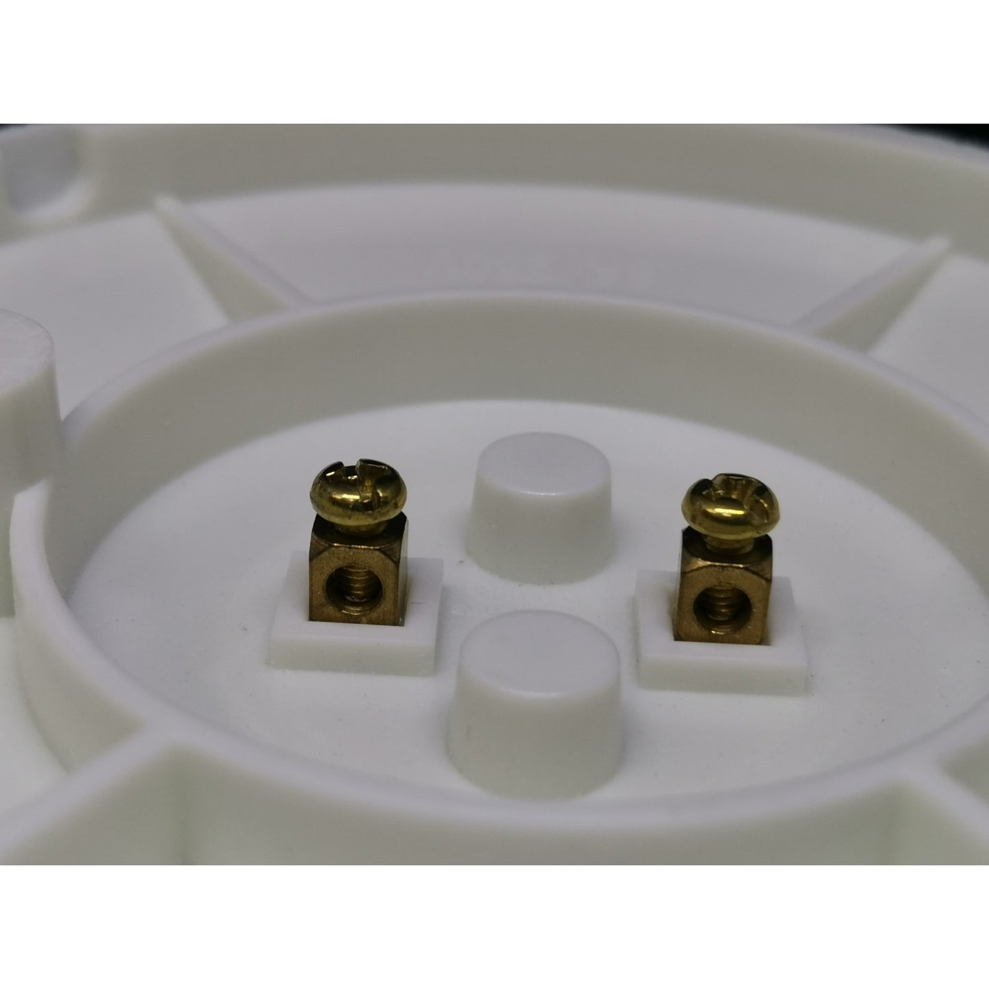 Close-up of a white circular component with gold and white parts on a white background