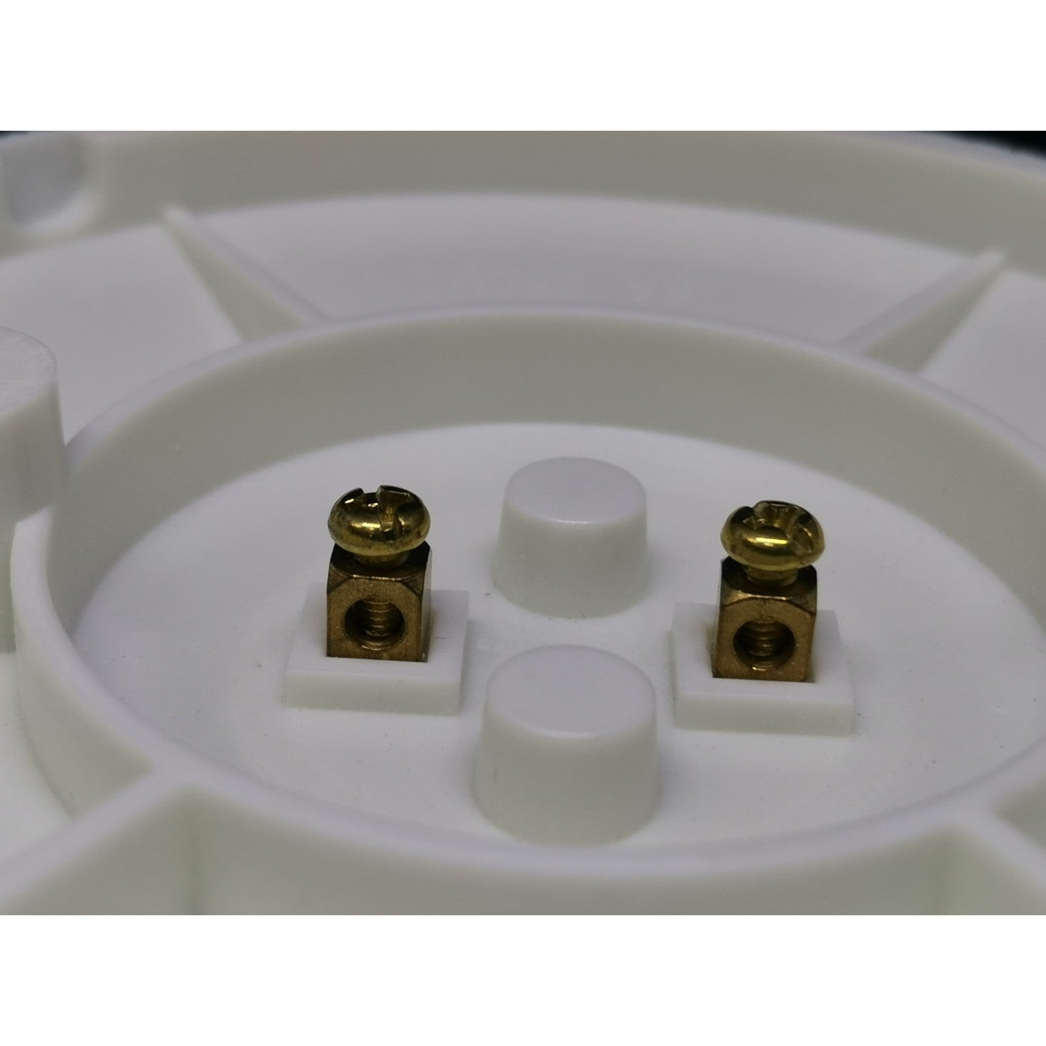 Close-up of a white circular component with gold and white parts on a white background
