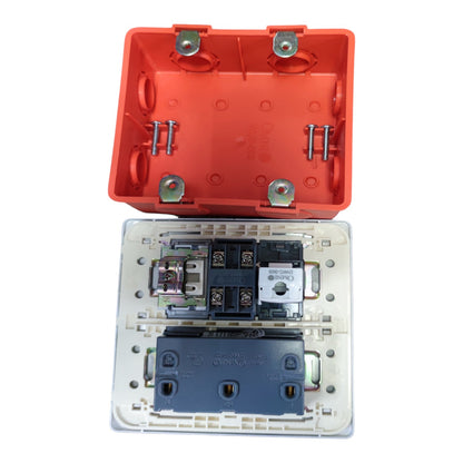 An electrical switch module shown open, with a bright orange upper housing lid positioned above a clear lower faceplate containing internal components including a dark blue terminal block and metal screws, photographed on a white background.