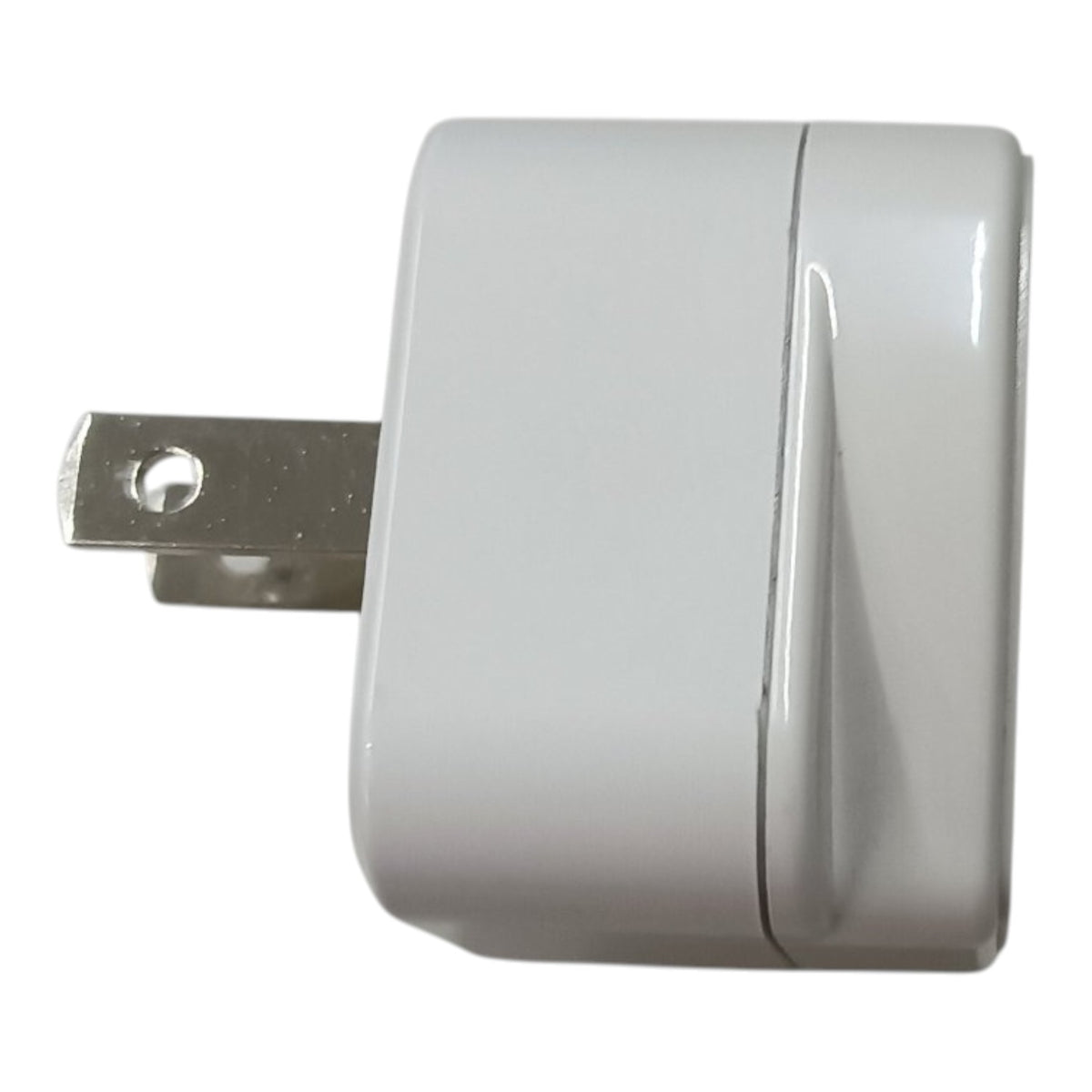 A white plastic wall charger or power adapter with a silver metal plug, shown against a plain white background.