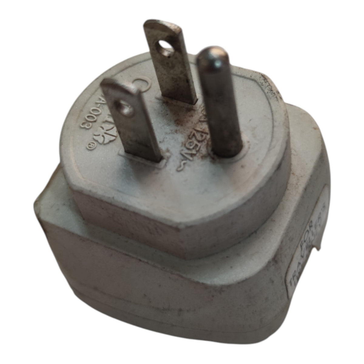 A gray plastic electrical outlet adapter plug with three metal pins, photographed on a plain white background.
