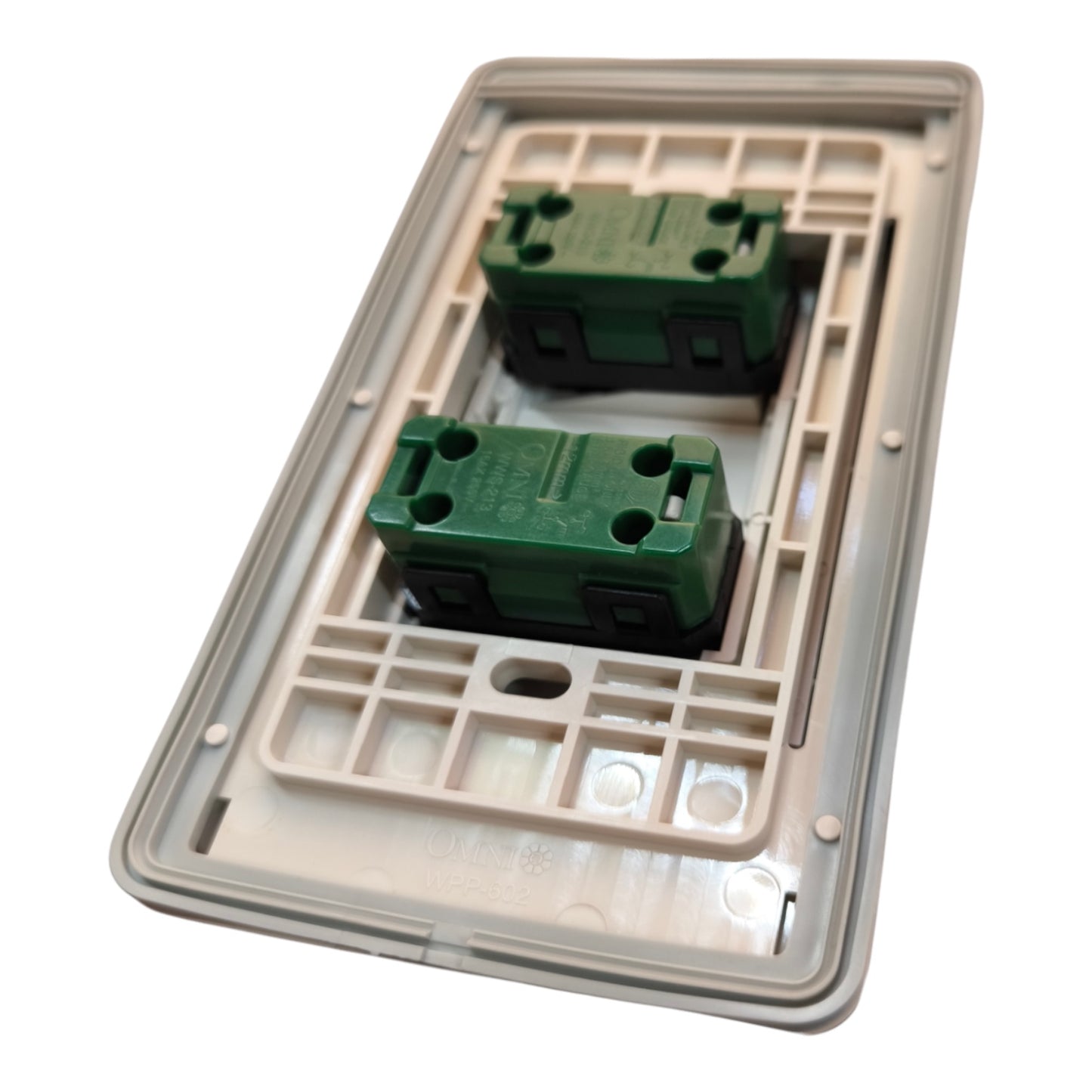 A double-gang wall switch plate cover with two green terminal blocks, shown from an angled top-down view on a white background.