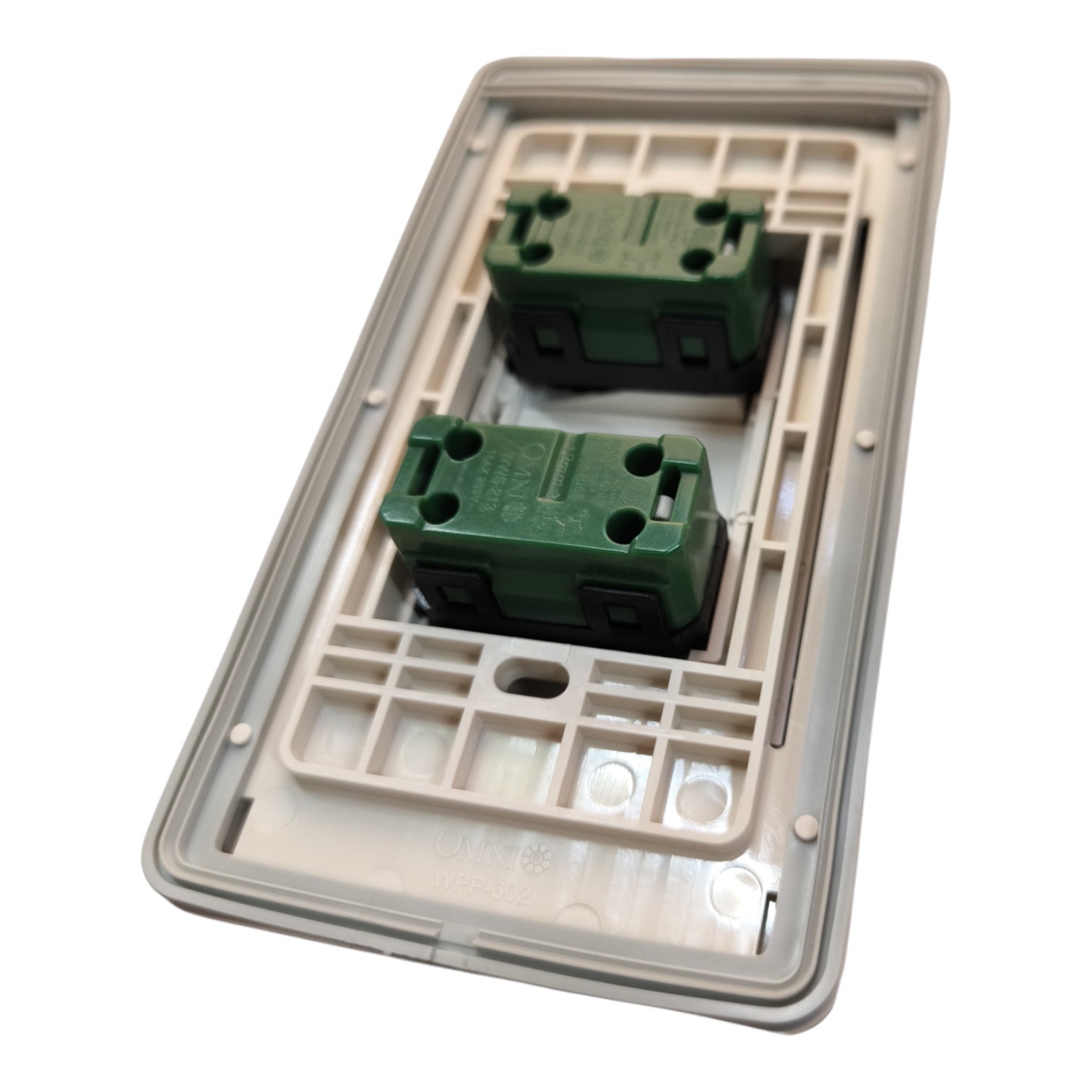 A double-gang electrical switch plate cover with two green terminal blocks set into a beige plastic backplate, shown on a white background.