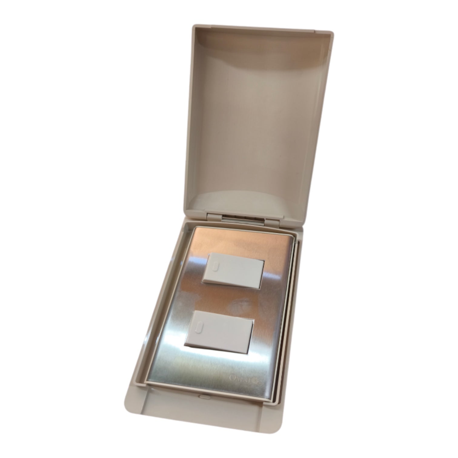 A beige plastic protective cover for a double light switch, shown open to reveal the silver metal switch panel inside, set against a plain white background.