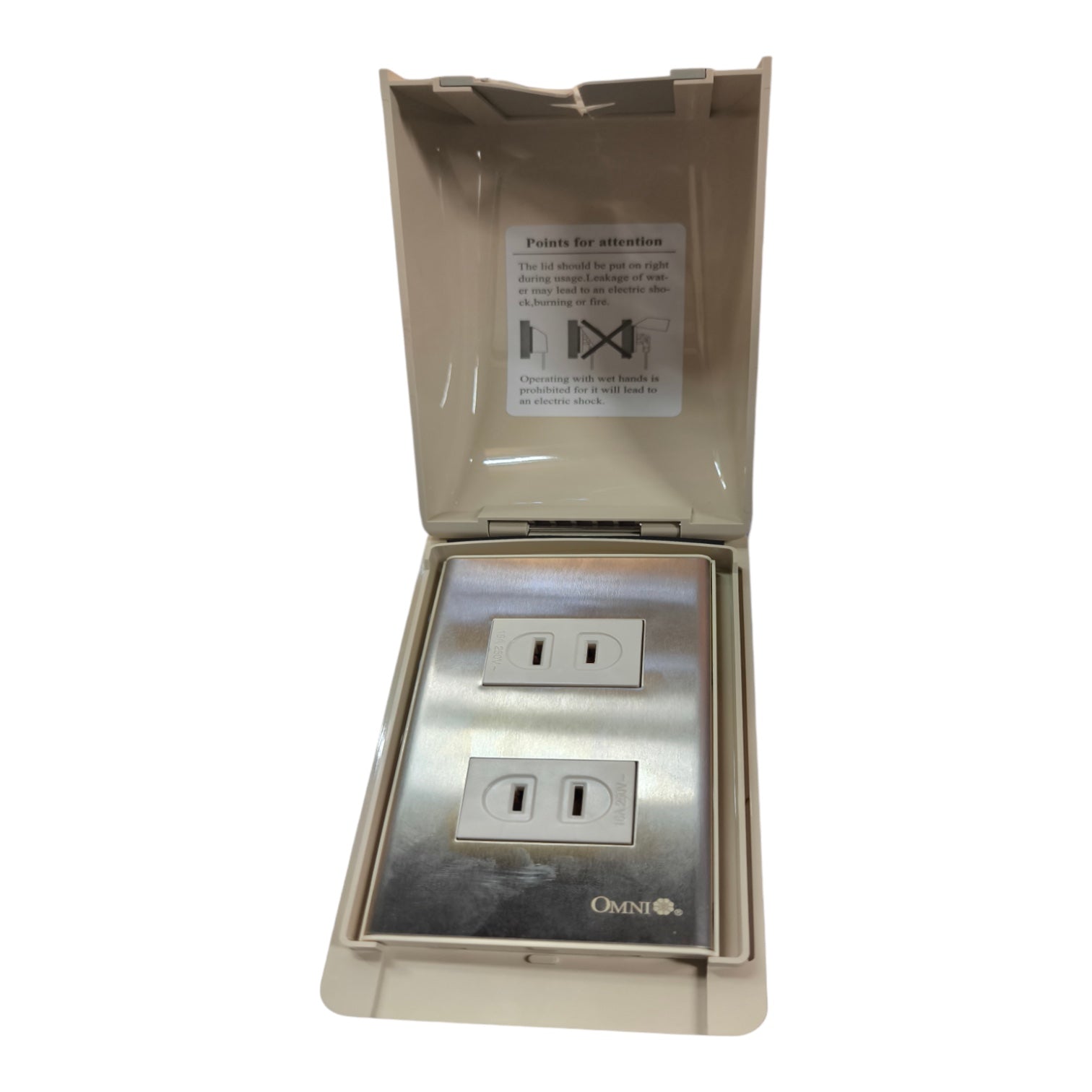 An outdoor duplex outlet cover with a stainless steel faceplate and a beige plastic hinged cover that is open, showing a warning label inside.