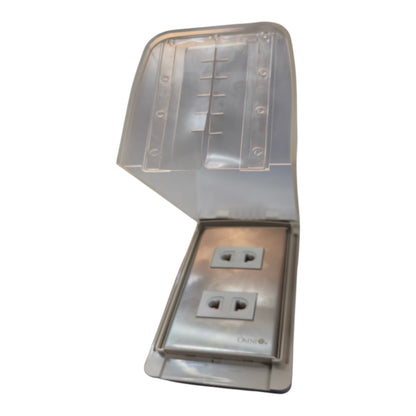A waterproof outdoor duplex outlet cover with an integrated rain cover that is shown open, revealing two US-standard electrical outlets on a metallic silver plate.