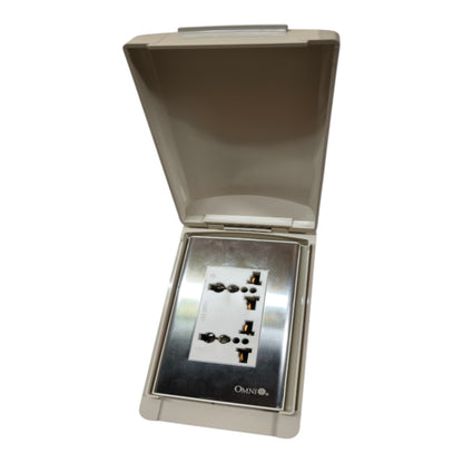 An open outdoor waterproof power outlet box with a beige plastic cover and a stainless steel faceplate containing four UK three-pin wall sockets. The brand name 'Owntz' is visible at the bottom of the plate.