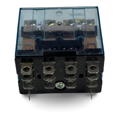 A black electrical relay with a transparent blue-tinted plastic cover, featuring four metal terminal blocks on the front and a small green circular detail near the bottom center, set against a plain white background.