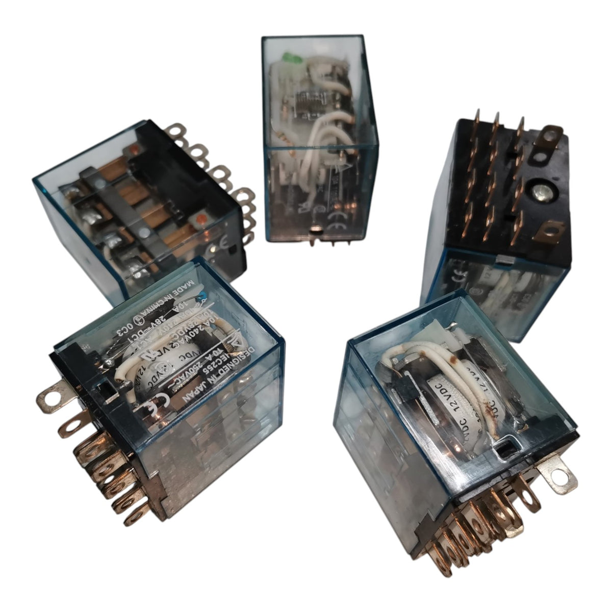 Five industrial electrical relays with transparent blue-gray plastic casings, showing internal wiring and metal terminals, arranged on a plain white background.