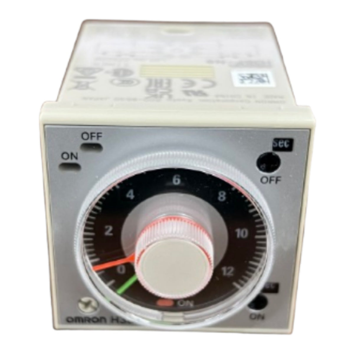 An Omron H-20 timer relay control module with a beige plastic housing, a silver metal faceplate, and a central rotary dial with a black scale, white center, and red markings.