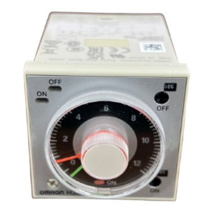 An Omron H-20 timer relay control module with a beige plastic housing, a silver metal faceplate, and a central rotary dial with a black scale, white center, and red markings.
