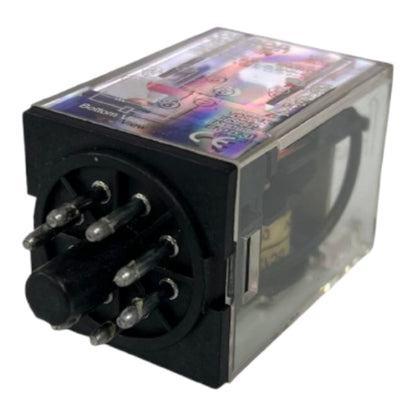 A black electrical relay with a clear plastic cover on one side, featuring multiple metal pins on the front and a colorful printed label on top, isolated on a white background.