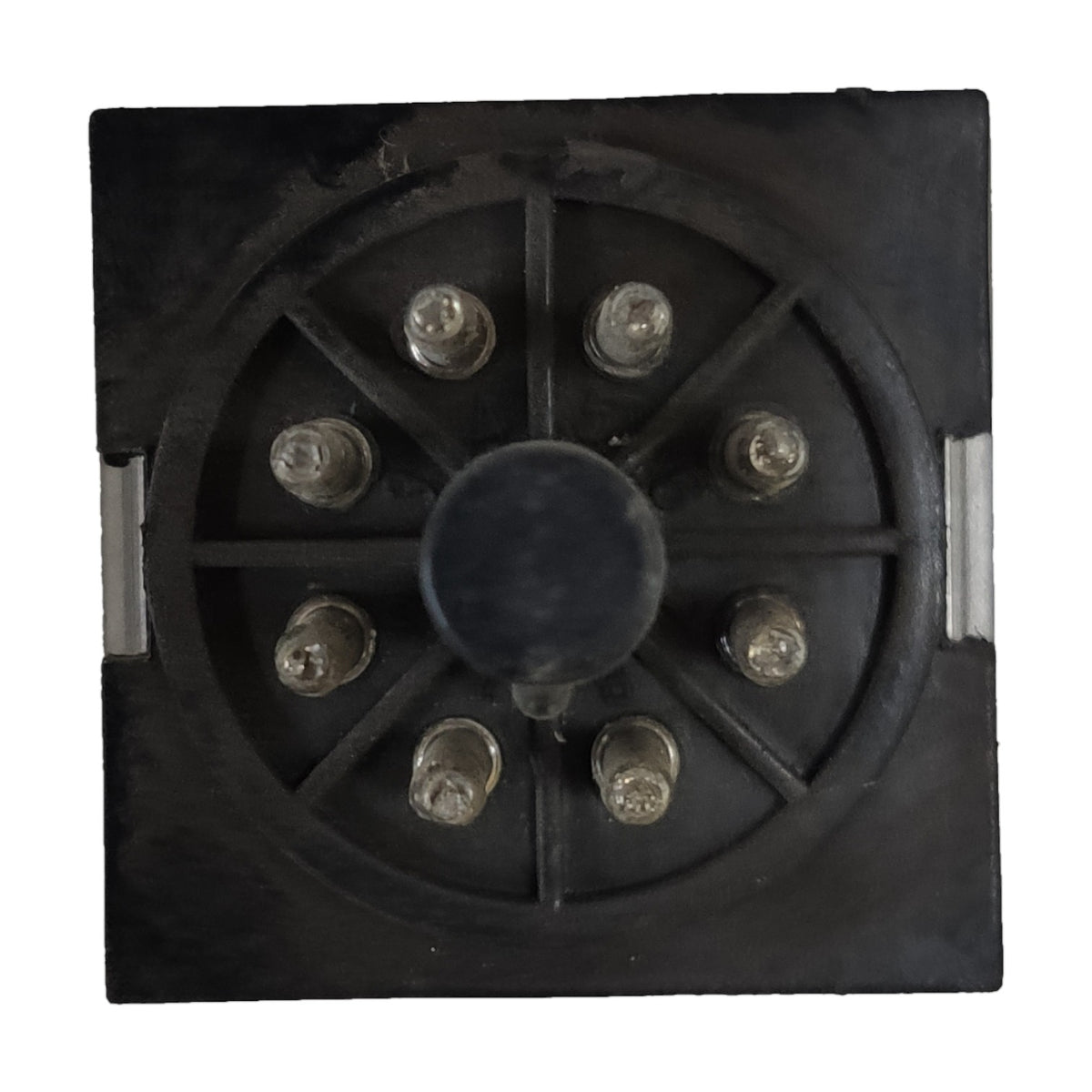 A square black metal electrical terminal block or connector with a circular radial pattern and eight silver screw terminals, shown against a plain white background.