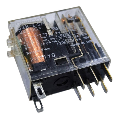 A small electrical relay component with a transparent plastic housing, black internal contacts, copper coil, and multiple metal terminal pins, photographed on a plain white background.