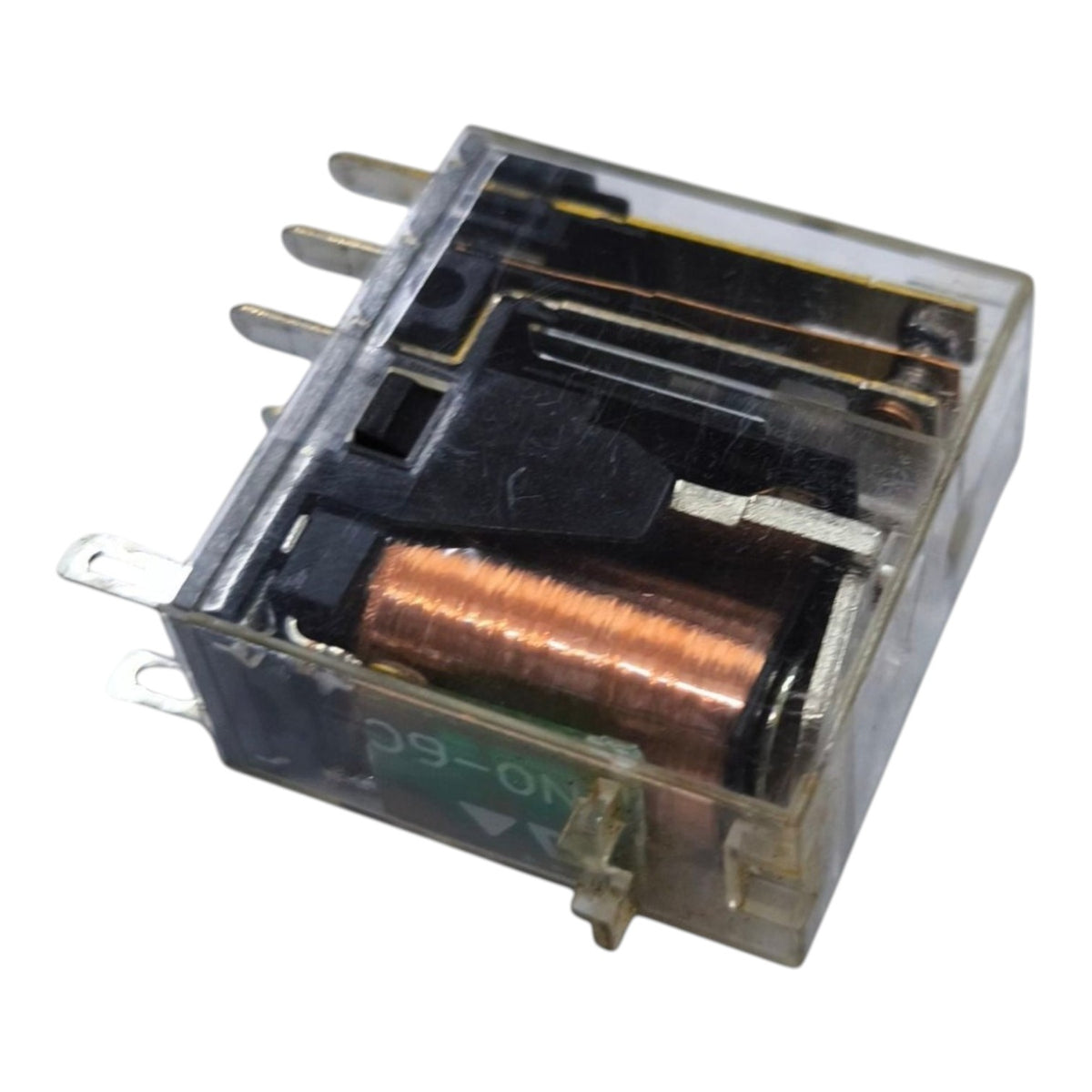 A small electrical relay component with a transparent plastic housing, copper coil, and metal terminals, shown on a plain white background.
