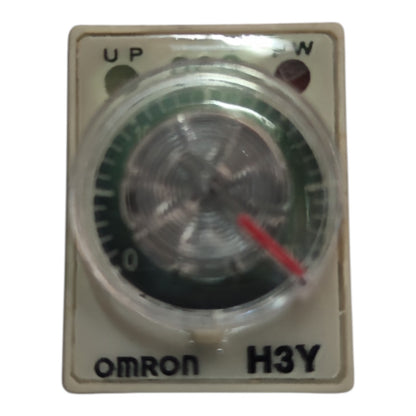 An Omron H3Y analog timer switch with a beige plastic housing, featuring a clear protective cover over a green and black dial with a red pointer, on a white background.