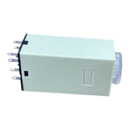 A small rectangular electronic component with a pale mint-green body, a black terminal strip on one end with several metal pins, a recessed button on the side, and a translucent circular element on the other end, shown on a plain white background.