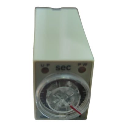 A small rectangular electronic timer or pump control unit with a beige plastic housing, a clear circular dial window, and red indicator lights on a white background.