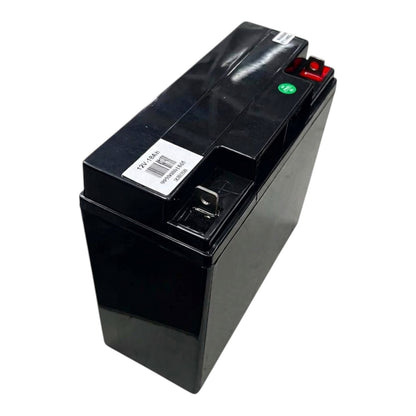 A black rectangular lead-acid battery with a white barcode label, a red terminal cap, and a green polarity indicator, photographed on a white background.