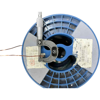 Blue spool with a micrometer on top against a white background
