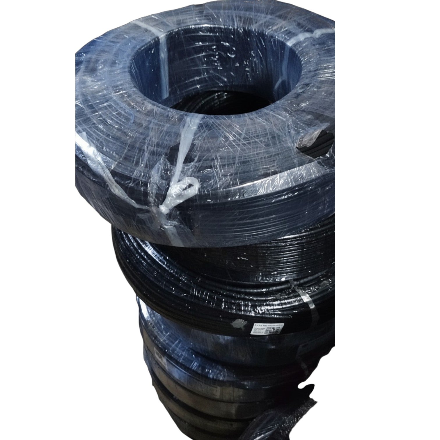 A stack of large black wire or cable reels wrapped in clear plastic, photographed against a plain white background.