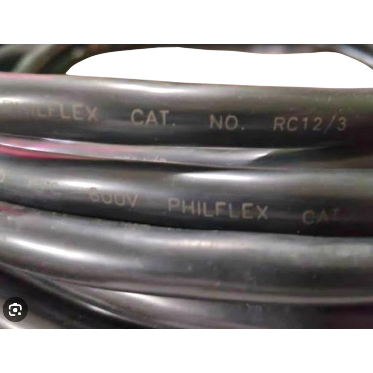 Close-up of coiled black Philflex hydraulic hose with white printed text including 'PHILFLEX', 'CAT.', 'NO.', and 'RC12/3'.