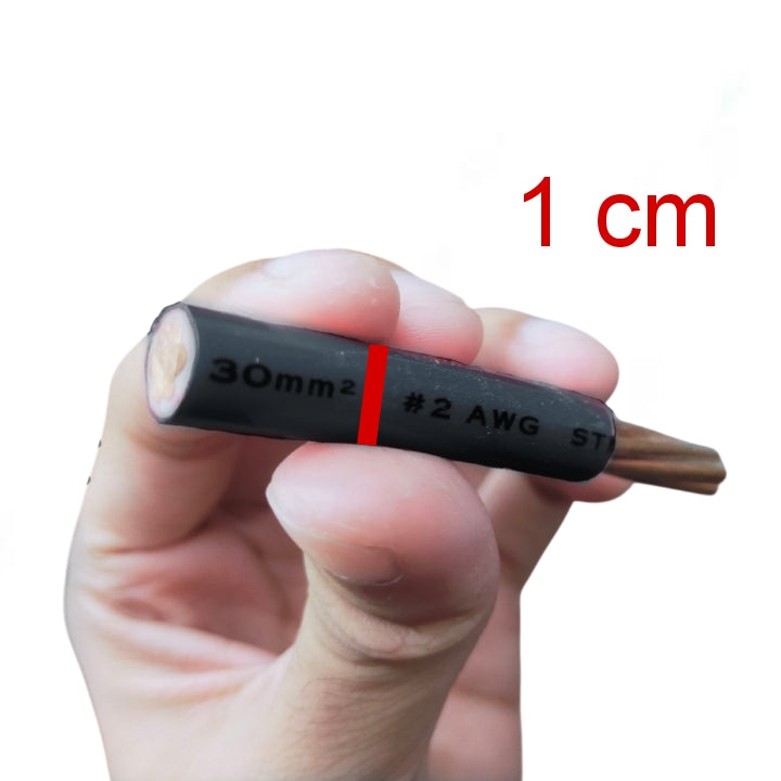 A hand holding a small black cable or wire connector with printed markings including '30mm2', '#2 AWG', and 'ST', with red text in the upper right reading '1 cm' on a plain white background.
