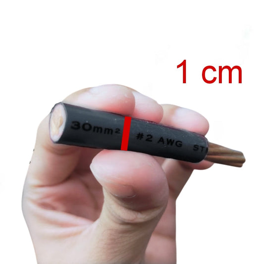 A hand holding a small black cable or wire connector with printed markings including '30mm2', '#2 AWG', and 'ST', with red text in the upper right reading '1 cm' on a plain white background.