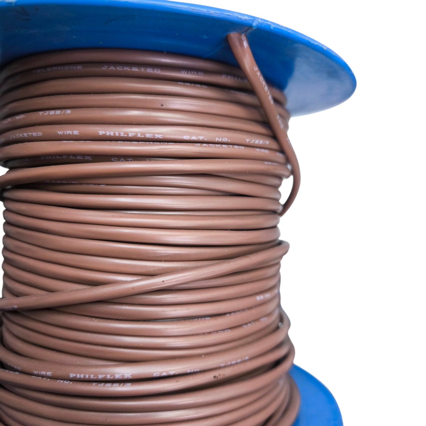 Spool of brown wire with a blue cap on a white background