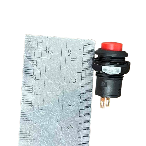 Red Push Lock 1A 220V switch next to a ruler for size reference