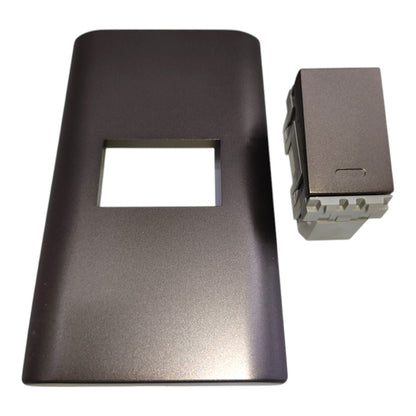 A dark gray rectangular faceplate with a rectangular cutout, shown next to a small matching gray component on a white background.