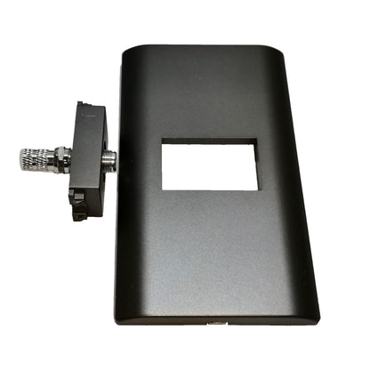 A black rectangular electronic enclosure or panel with a square cutout, shown next to a small black mounting bracket with a silver threaded connector, on a plain white background.