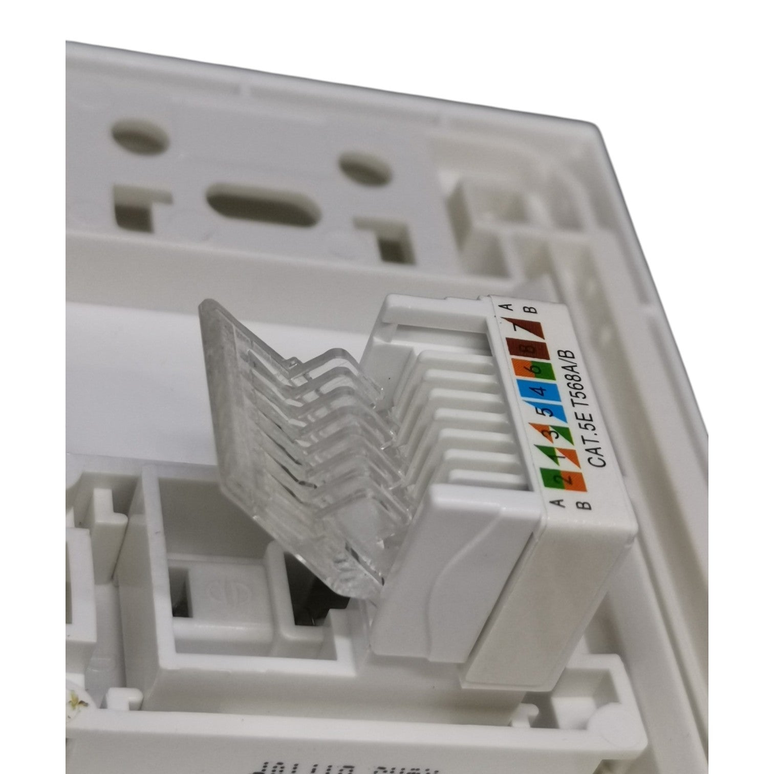 White RJ45 network module with a clear plastic cover and a color-coded port label showing Ethernet pin assignments, photographed close-up against a white background.