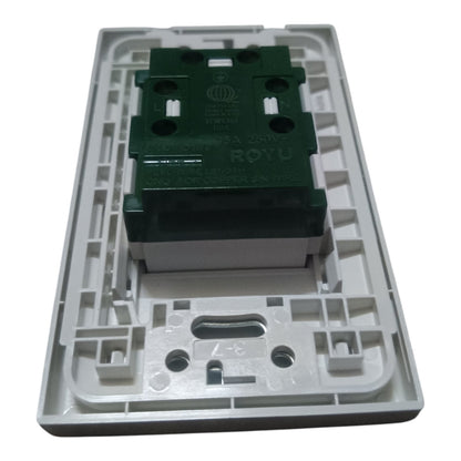 The underside of a circular black plastic device, likely a smart speaker or electronic control module, showing internal metal contacts, a barcode sticker, and a small pink tag on a white background.