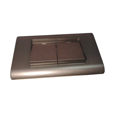 A modern two-button switch plate in a dark metallic bronze finish, shown from a high angle against a plain white background.
