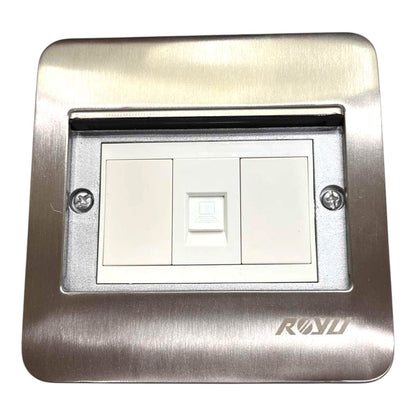 A modern brushed stainless steel double light switch plate with a white double-gang switch in the center, featuring a recessed socket on the left side and the RAVO brand logo on the bottom right.