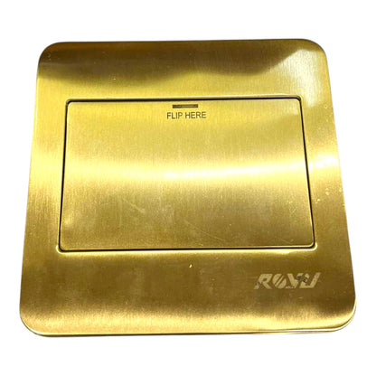 A brushed brass or gold-toned flush valve trim plate with a recessed center panel labeled 'FLIP HERE' and the brand name 'RAVI' in the bottom right corner, shown on a plain white background.
