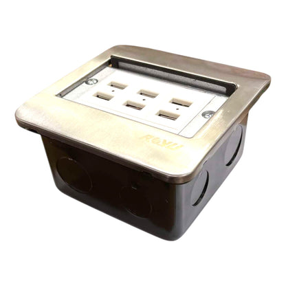 A recessed electrical outlet box with a brushed brass faceplate and a white multi-socket outlet panel, set against a plain white background.