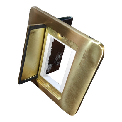 A square wall switch plate cover with a brushed brass/gold finish, shown open to reveal the white socket compartment and dark backplate inside, isolated on a white background.